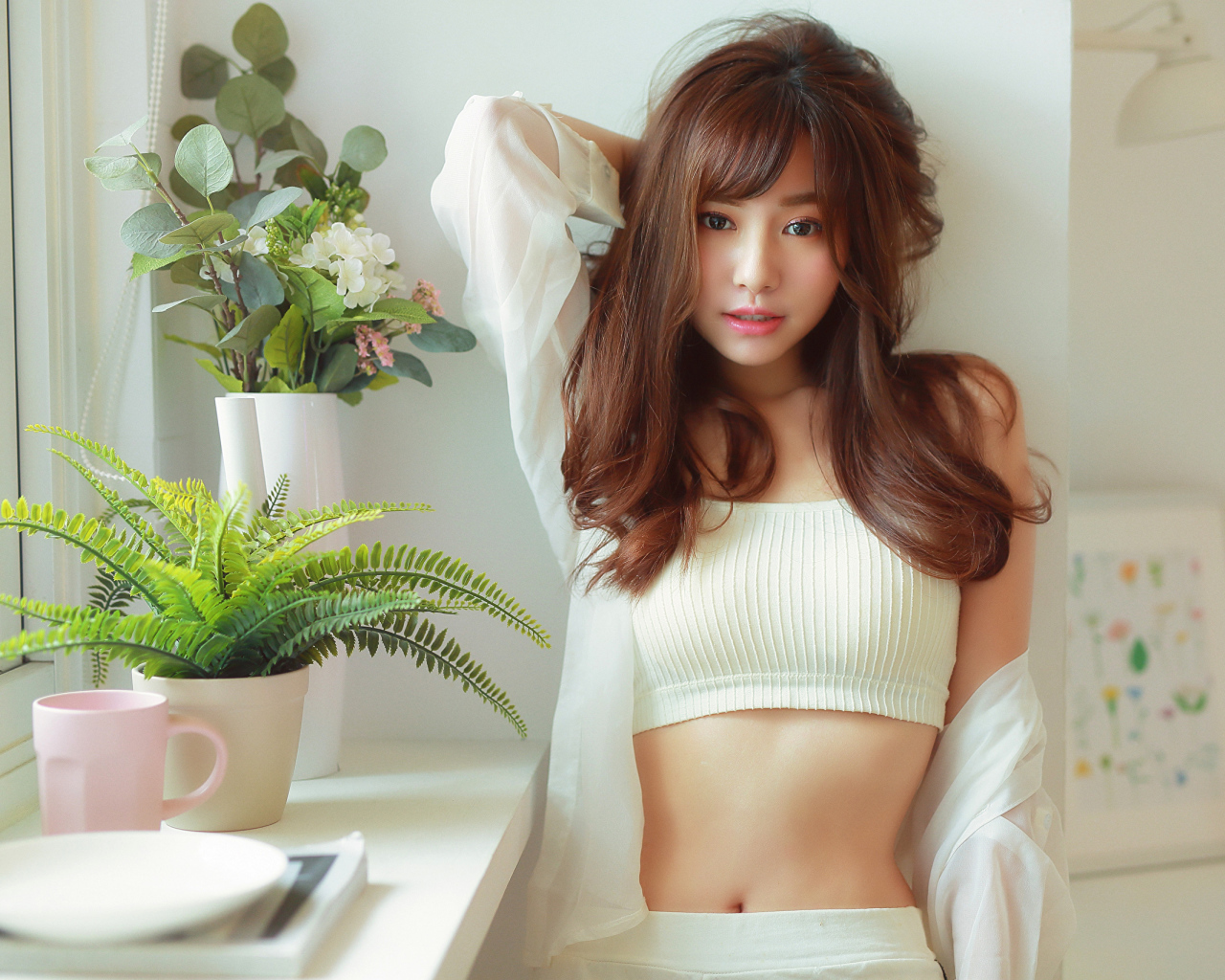 Нежная девушка азиатка стоит у окна