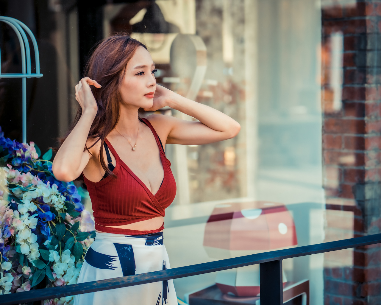 Нежная девушка азиатка стоит на балконе 