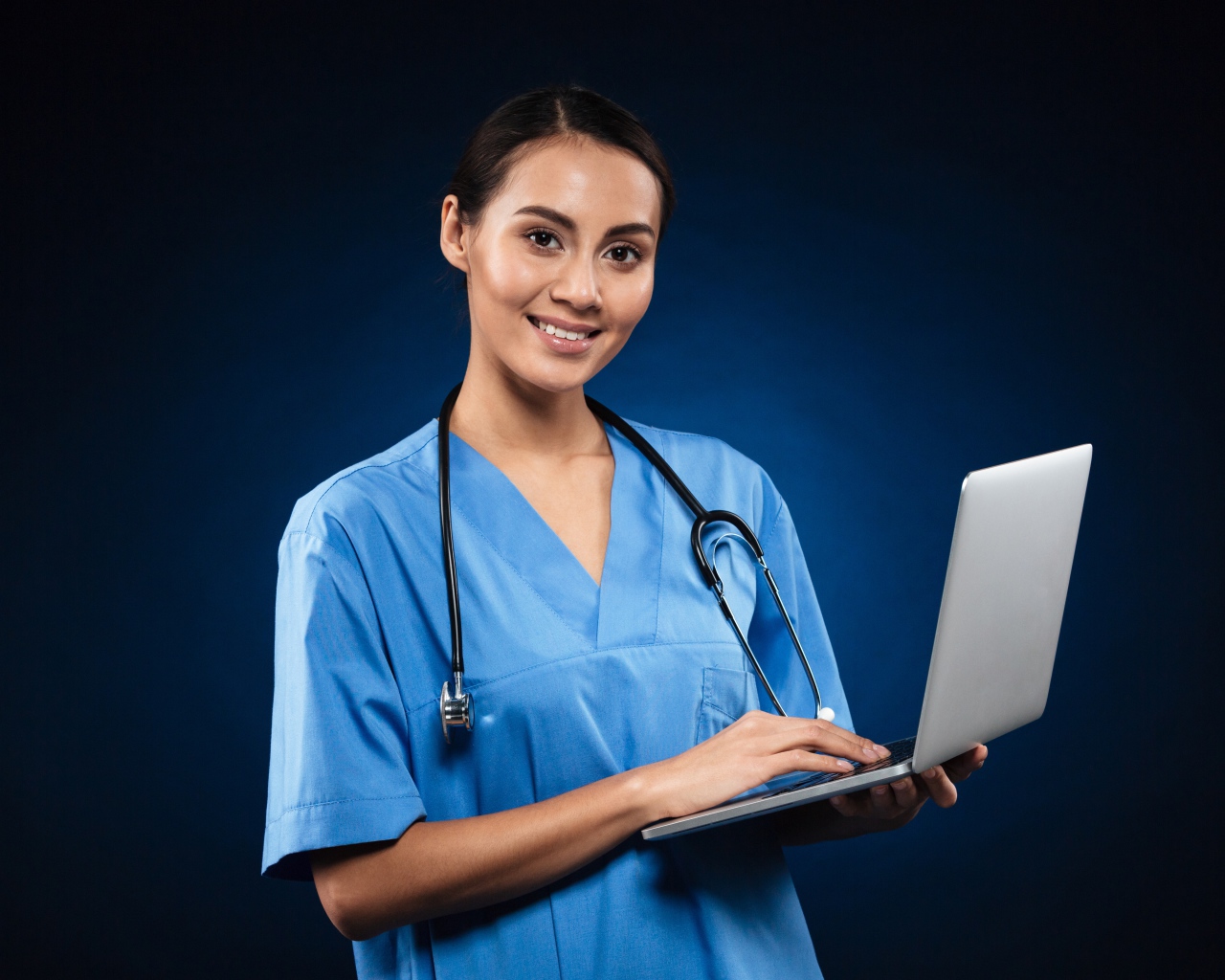 Девушка врач с ноутбуком на синем фоне 