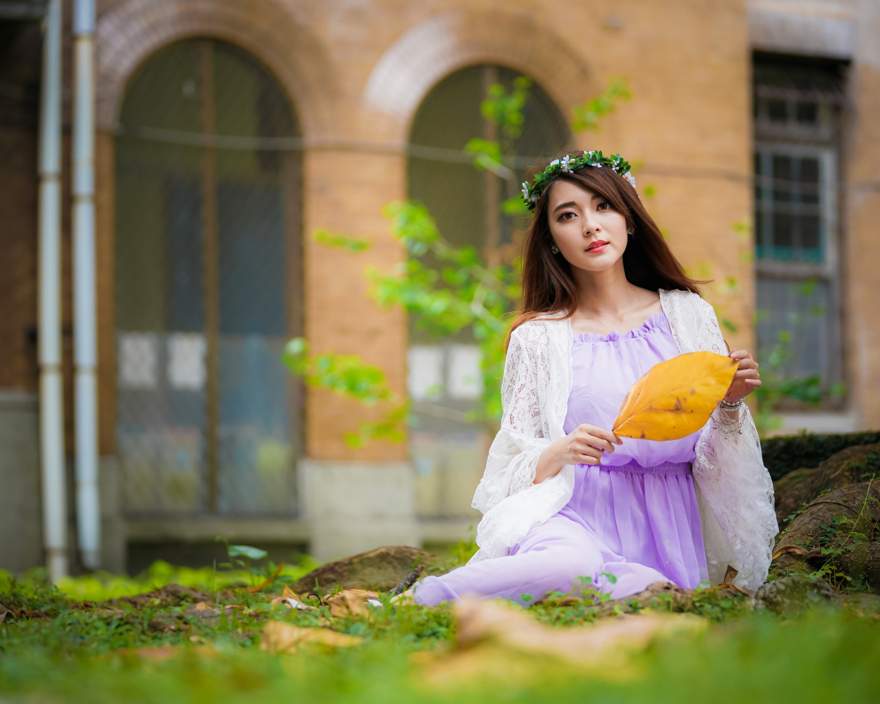 Девушка в красивом платье сидит на траве 