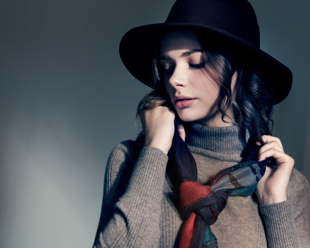 Девушка в сером свитере с платком на шее в черной шляпе