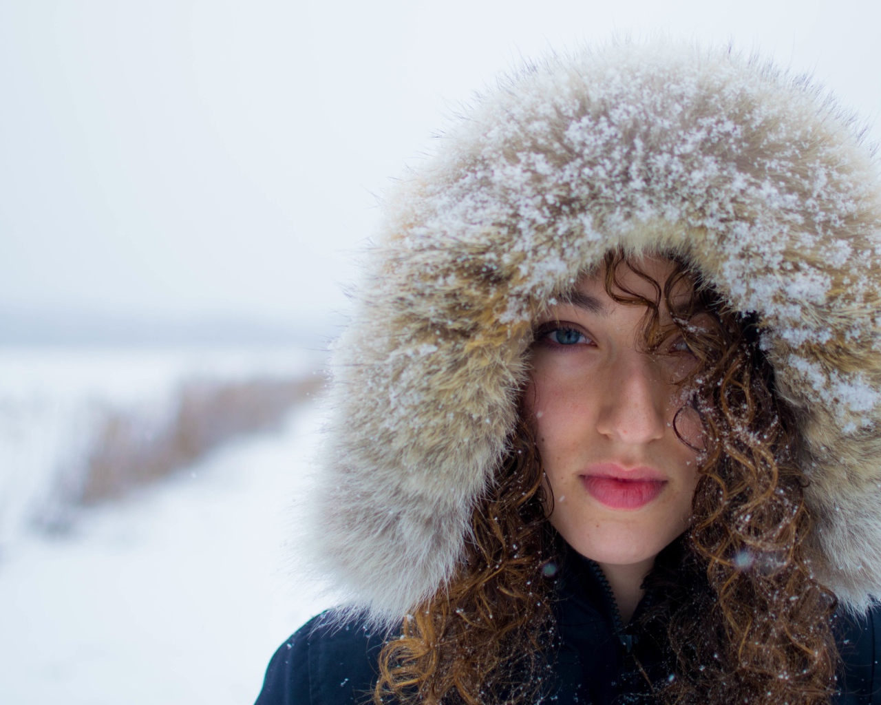 Девушка в заснеженном капюшоне на улице