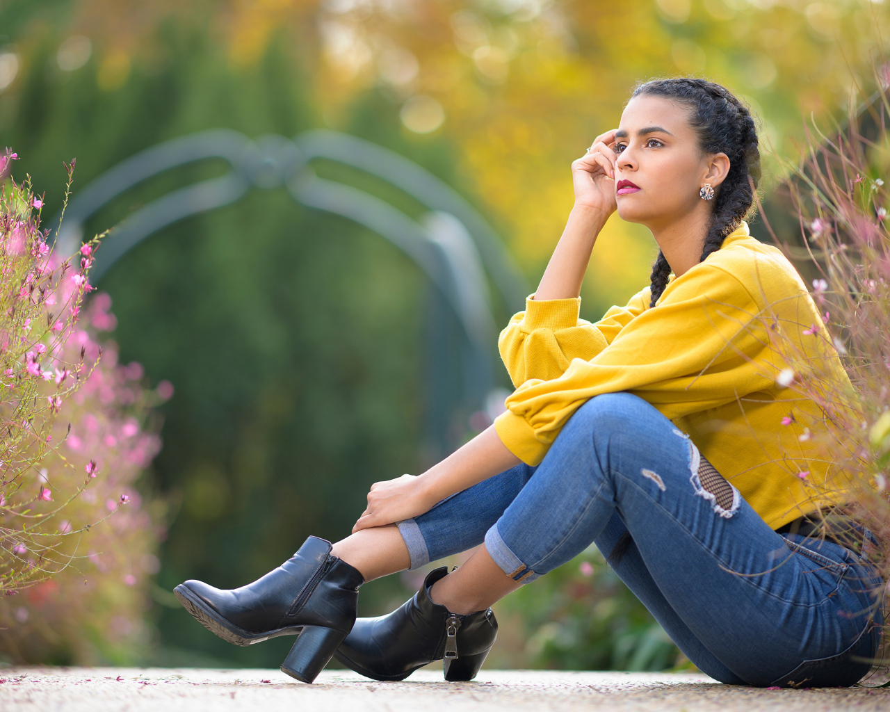 Девушка в джинсах сидит на земле 