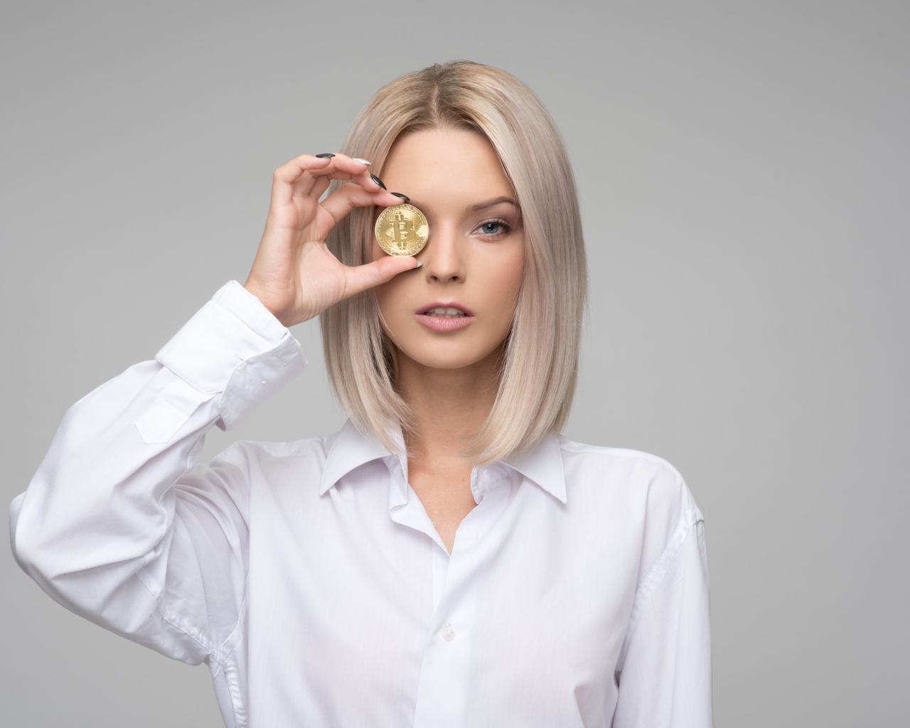 Девушка в белой рубашке с монетой биткоин 