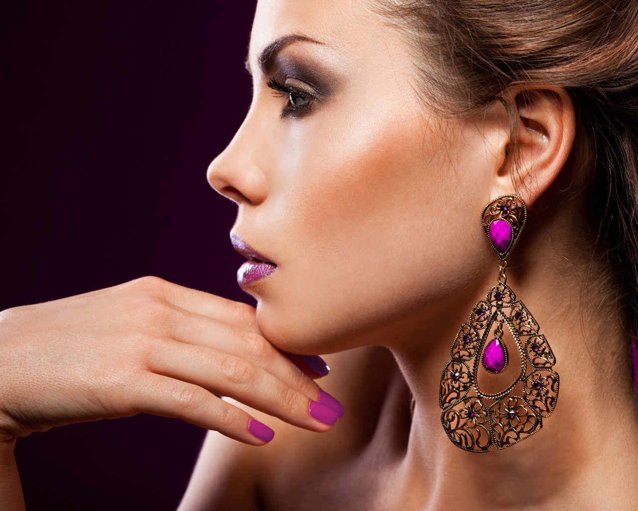Лицо девушки с красивым макияжем и дорогими серьгами