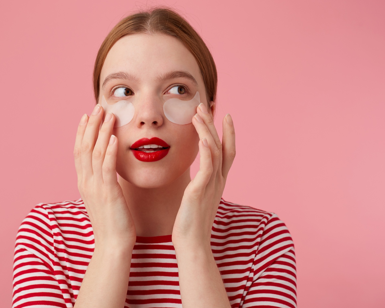 Девушка приклеивает патчи для глаз на лицо 