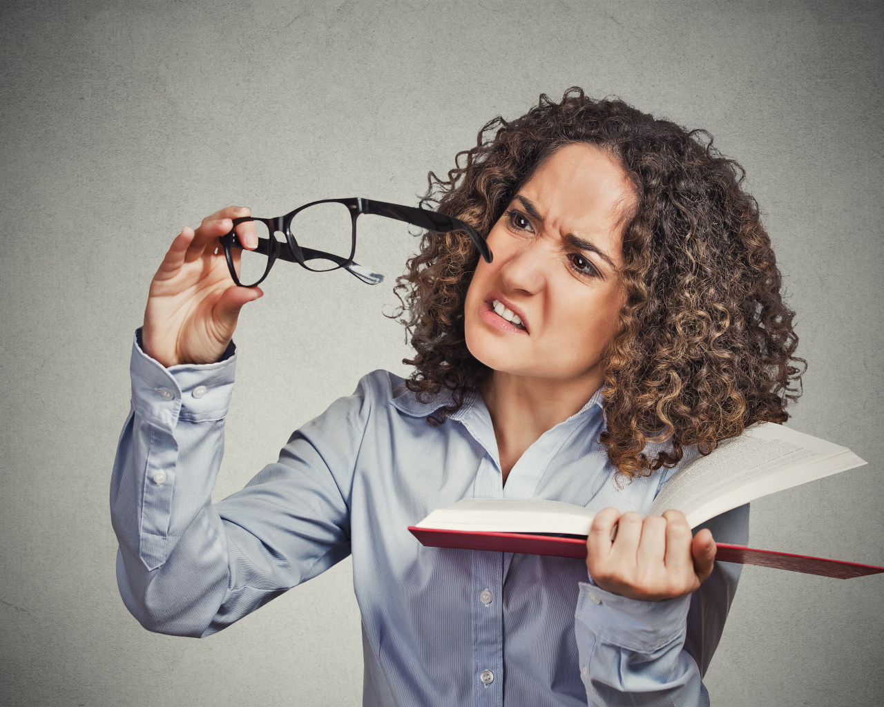 Девушка с книгой с очками в руке