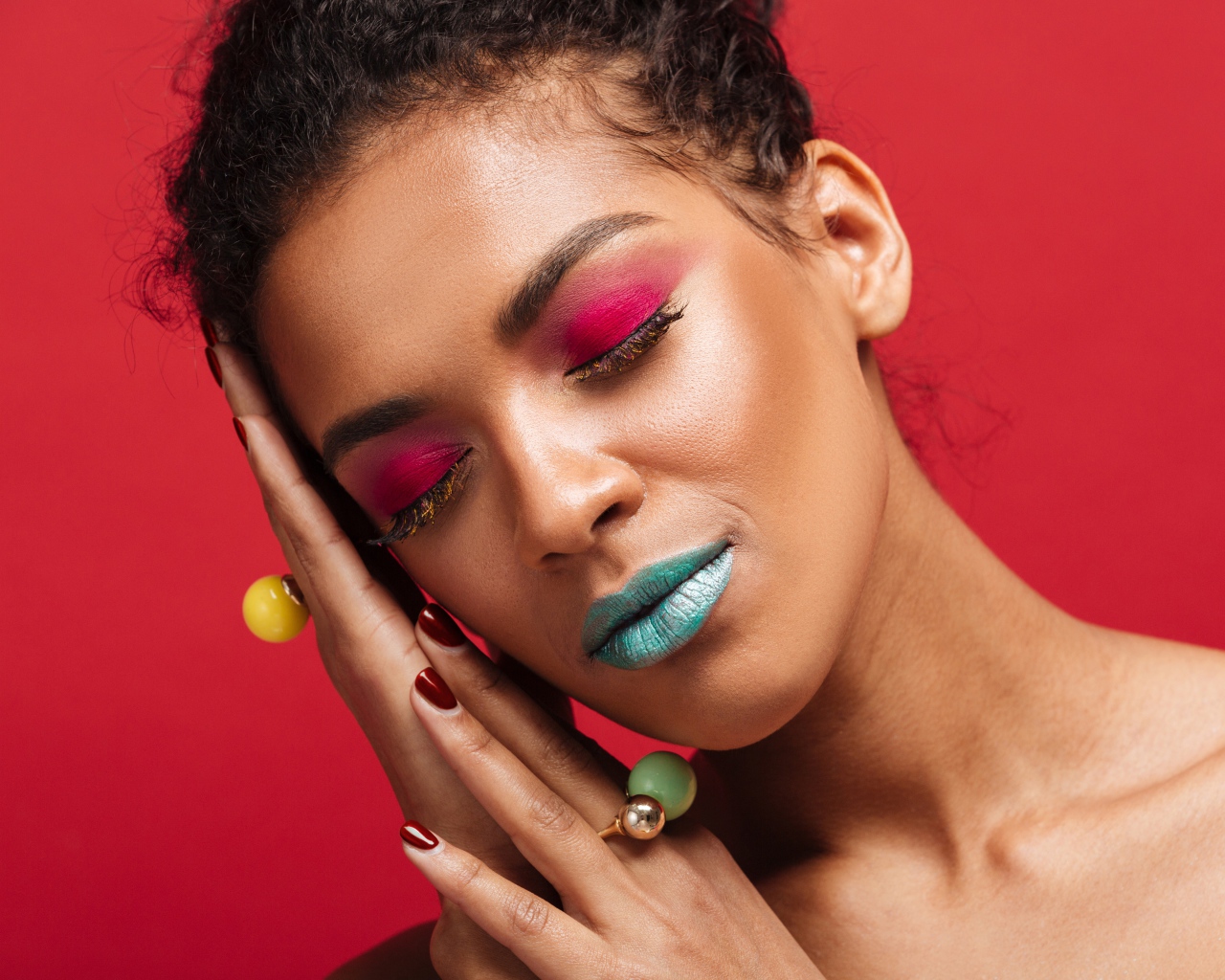 Девушка с ярким макияжем на красном фоне