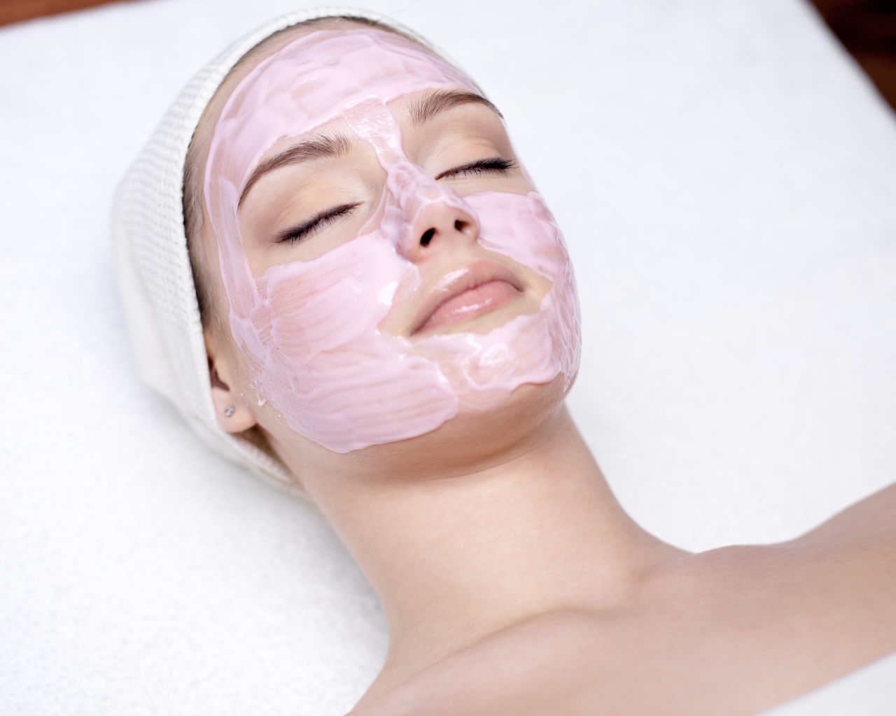 Девушка с закрытыми глазами на столе  у косметолога 