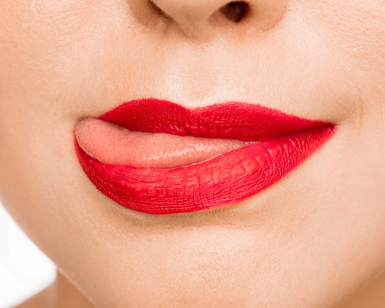 Девушка с  красными губами показывает язык