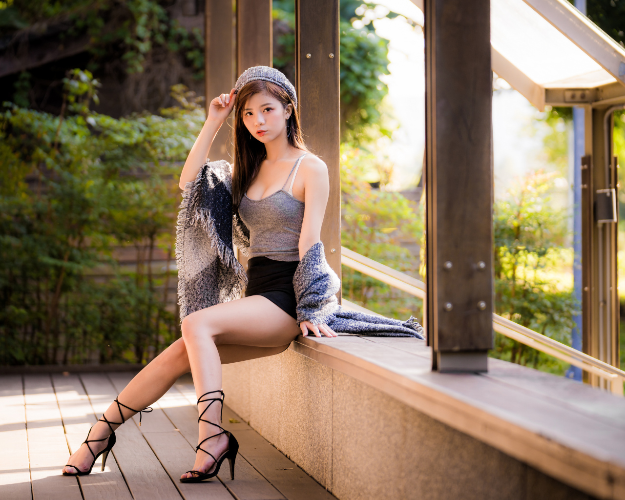 Длинноногая азиатка сидит на окне 