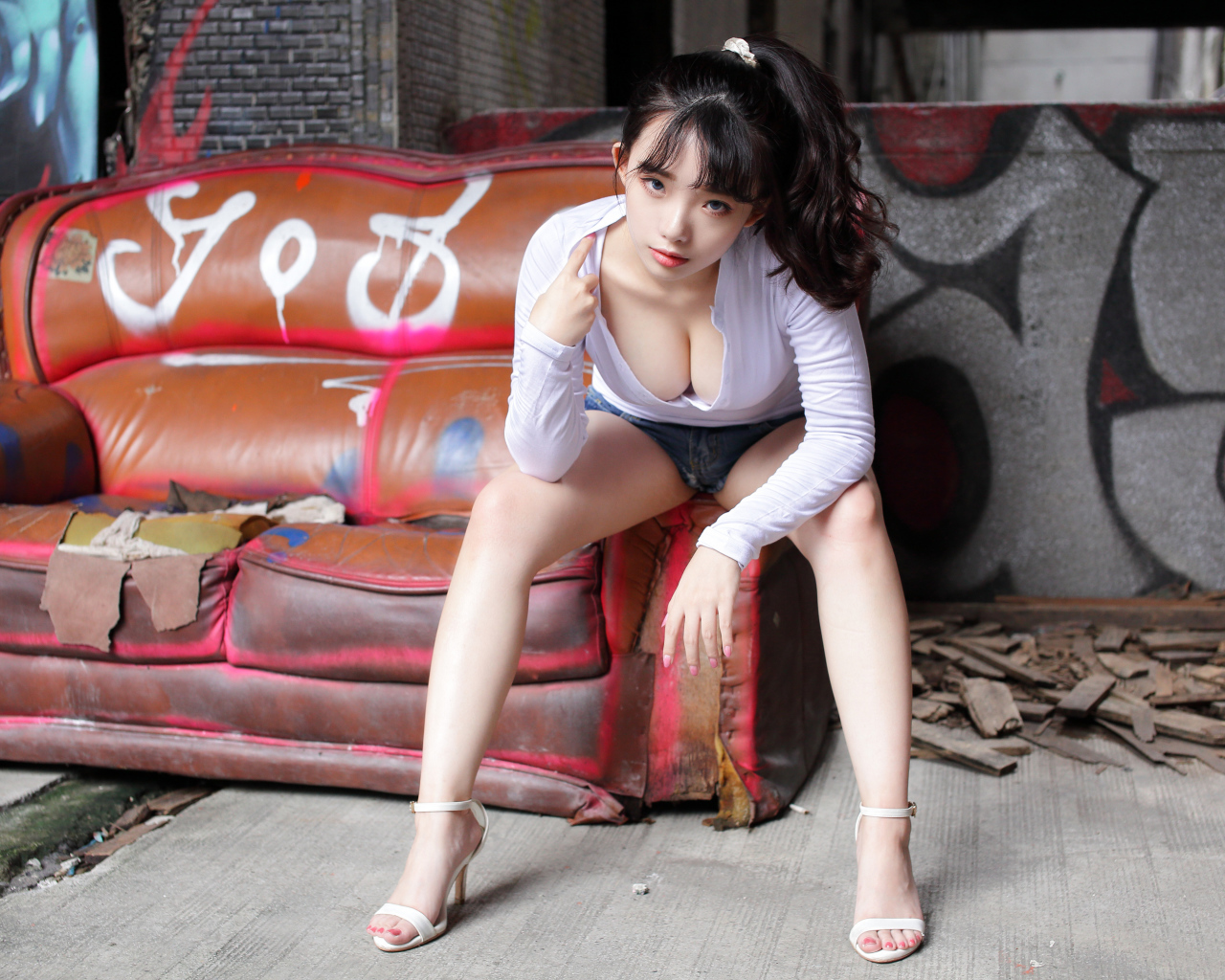 Длинноволосая девушка азиатка сидит на старом диване