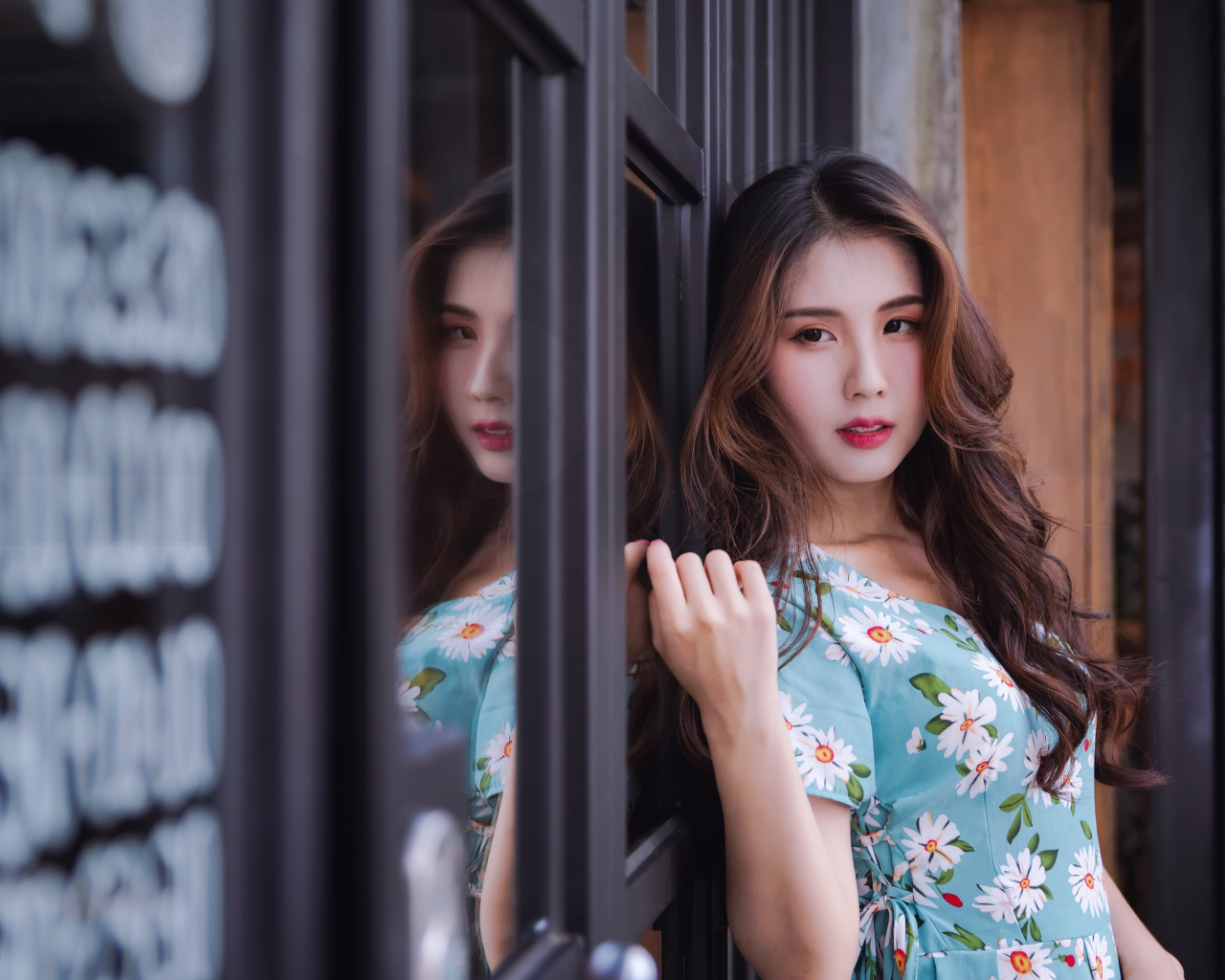 Длинноволосая девушка азиатка стоит у окна