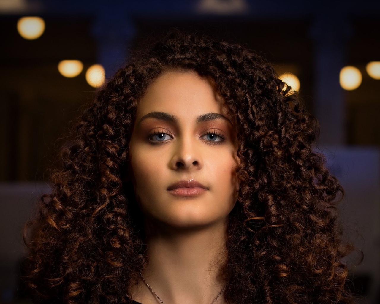 Длинные кудрявые волосы у красивой голубоглазой девушки