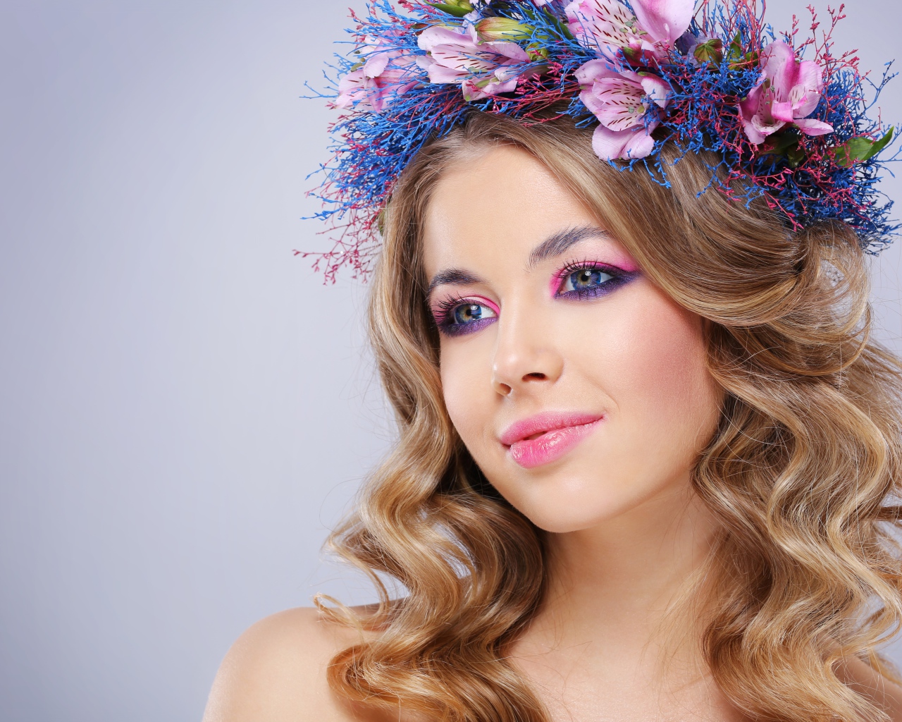 Милая девушка с венком на голове на сером фоне 