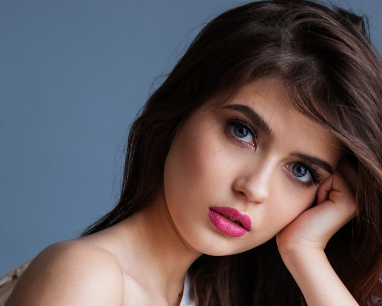 Милая девушка с розовыми губами на сером фоне