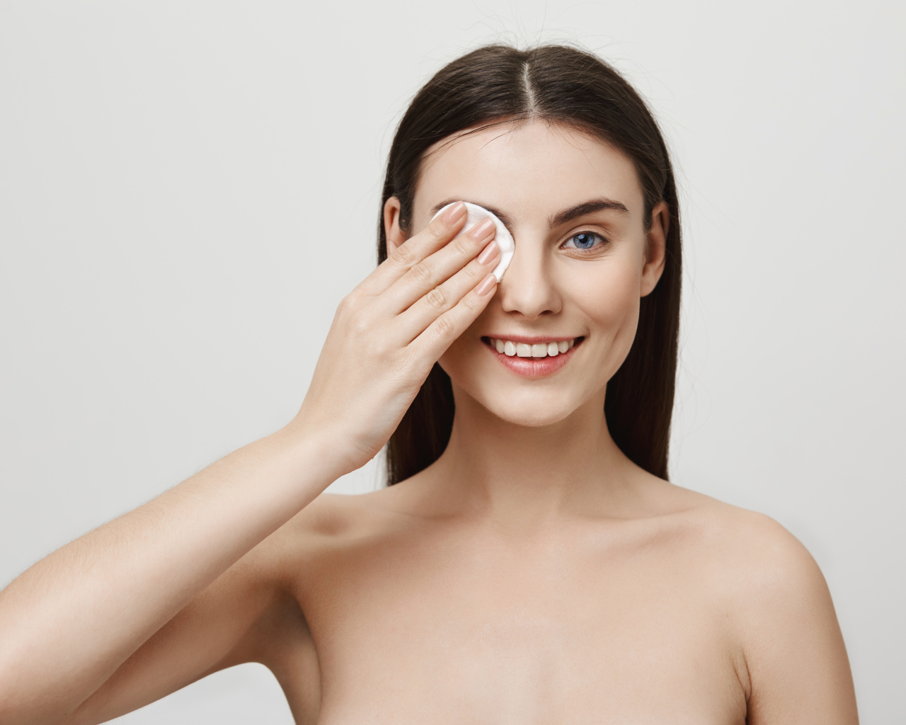 Настоящая голубоглазая девушка снимает макияж с лица