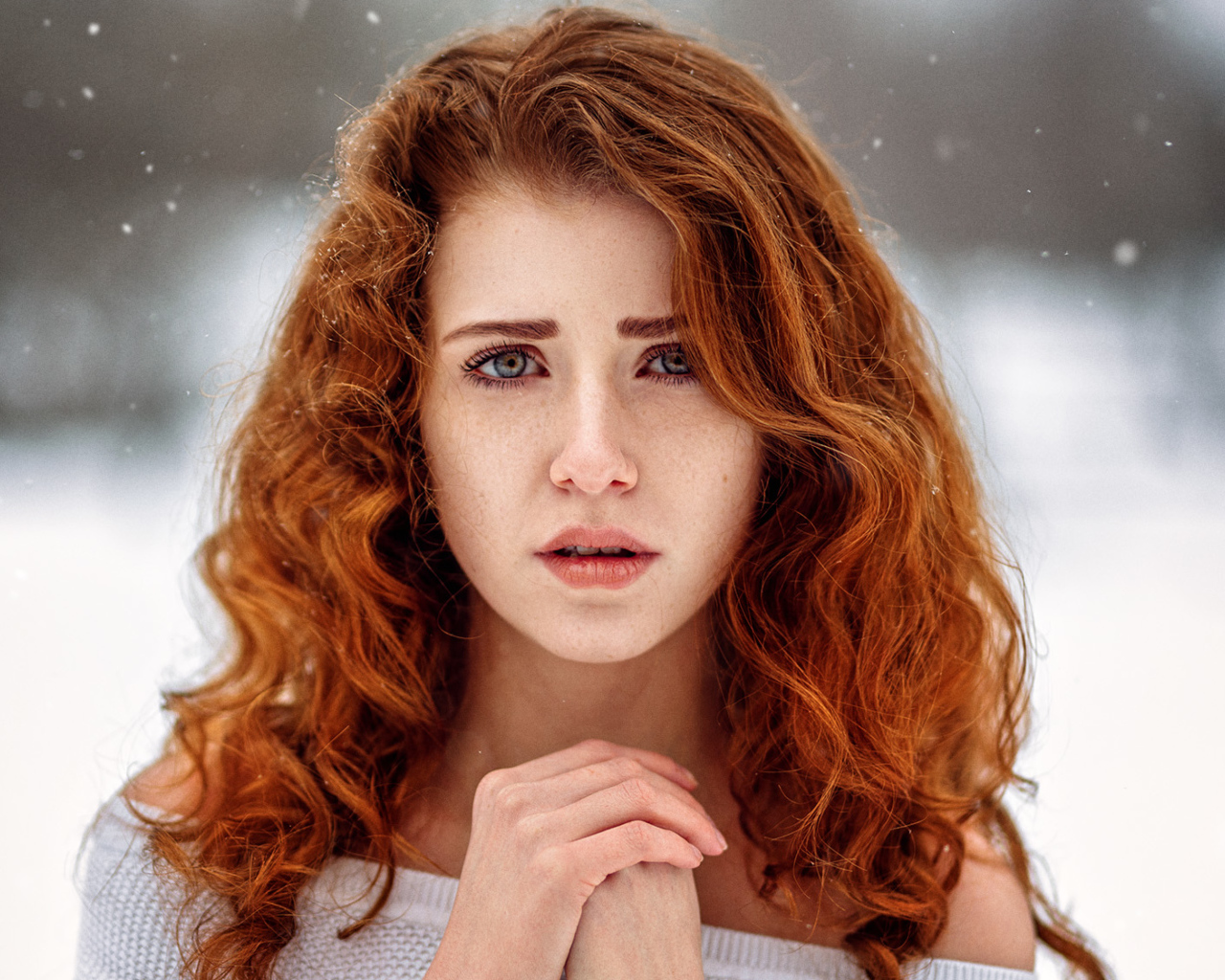 Рыжеволосая девушка замерзает на улице зимой