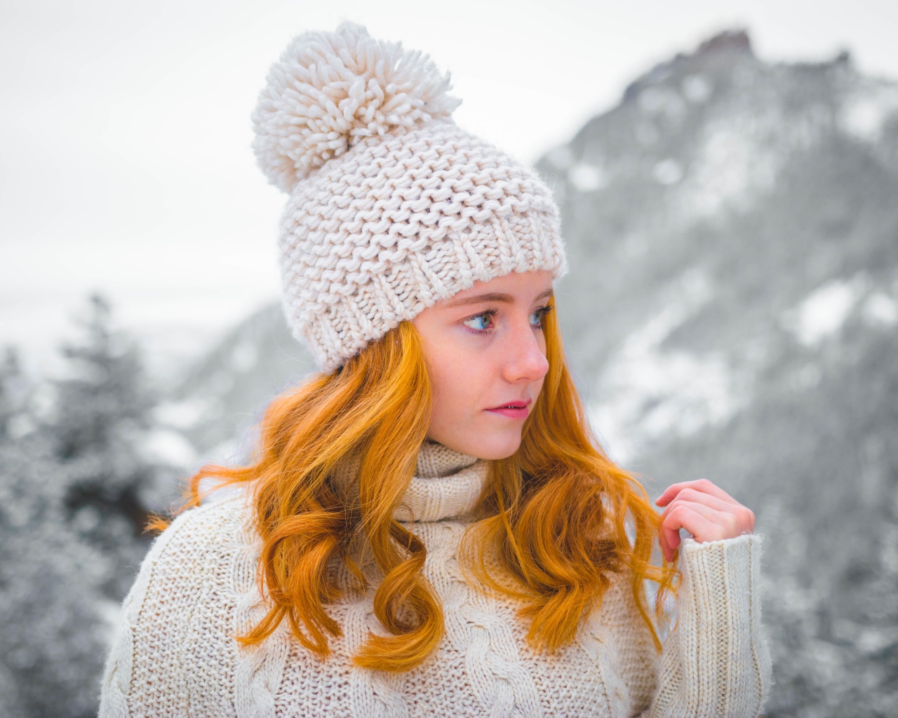 Рыжеволосая девушка в теплой шапке зимой 