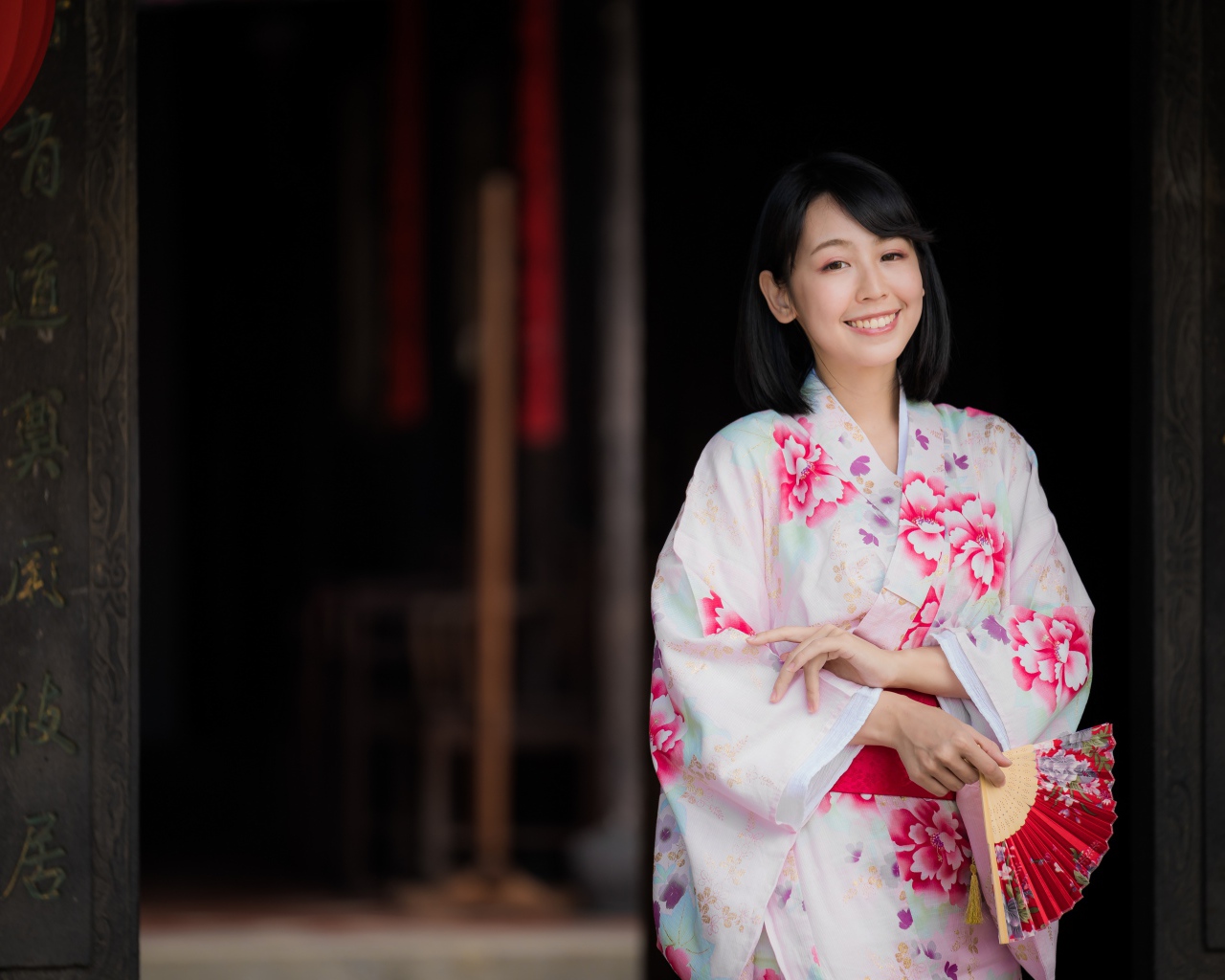 Улыбающаяся девушка азиатка в кимоно с веером в руке