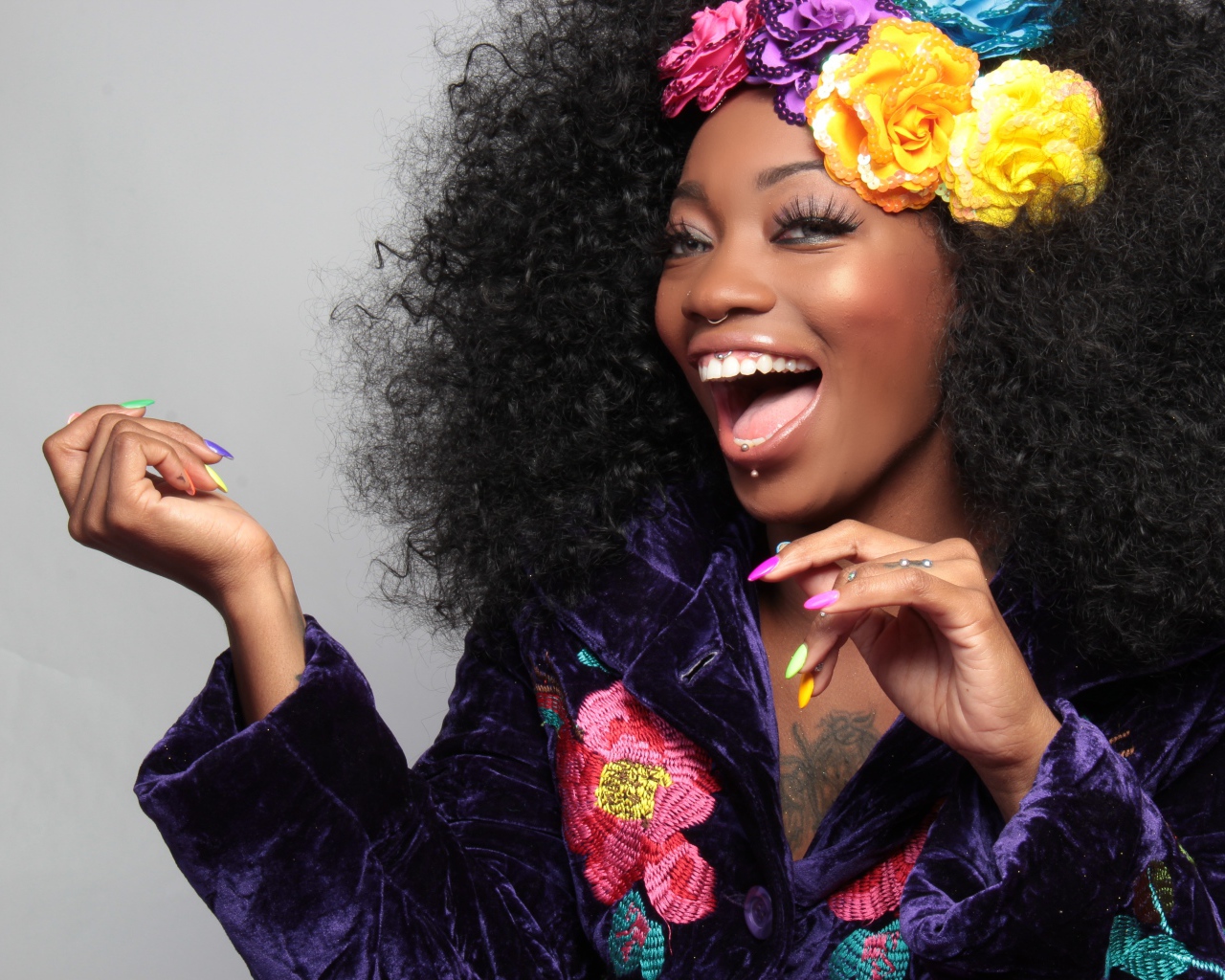 Улыбающаяся темнокожая девушка с цветами в волосах 