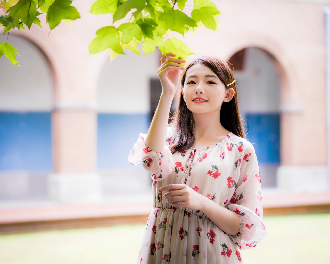 Улыбающаяся девушка в платье у дерева 