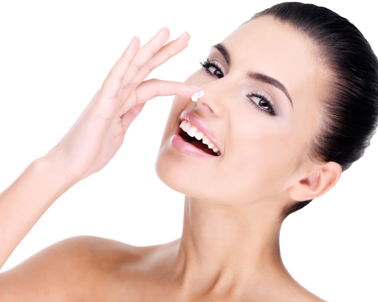 Улыбающаяся девушка мажет крем на нос 