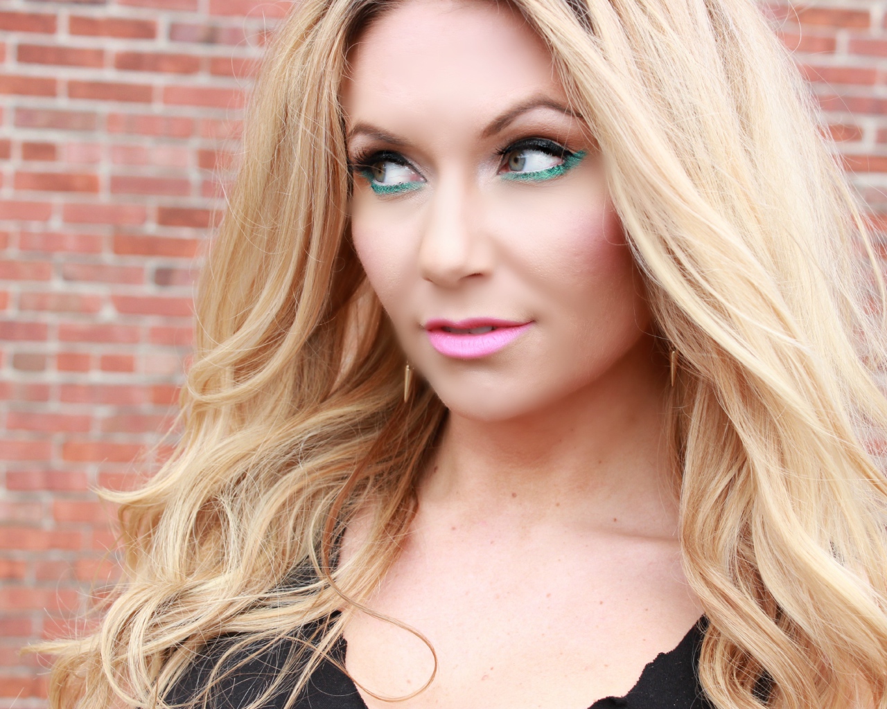 Эффектная длинноволосая блондинка у стены 