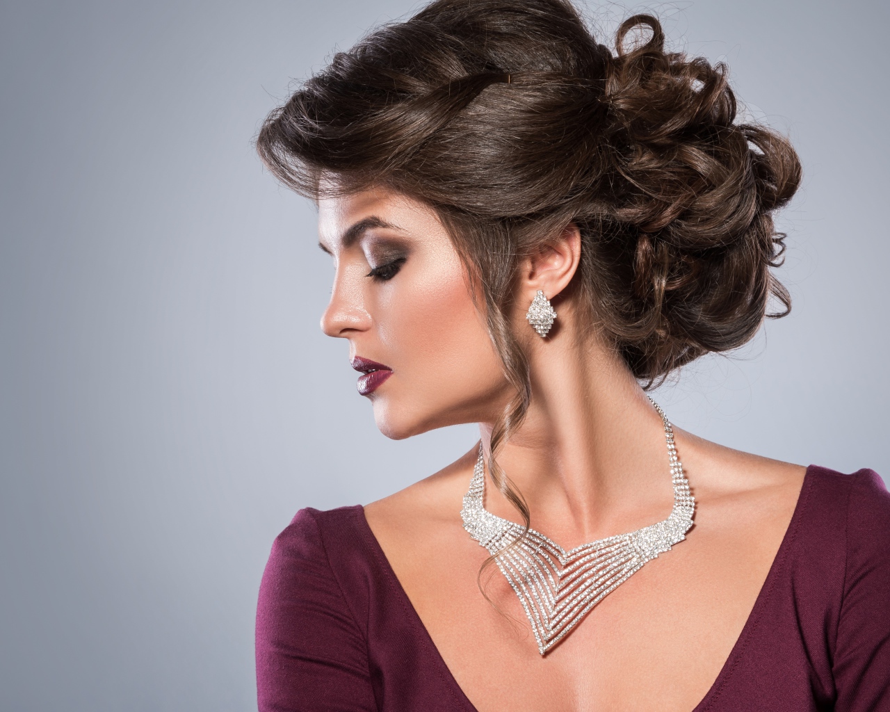 Стильная женщина с вечерней прической, макияжем и дорогими украшениями