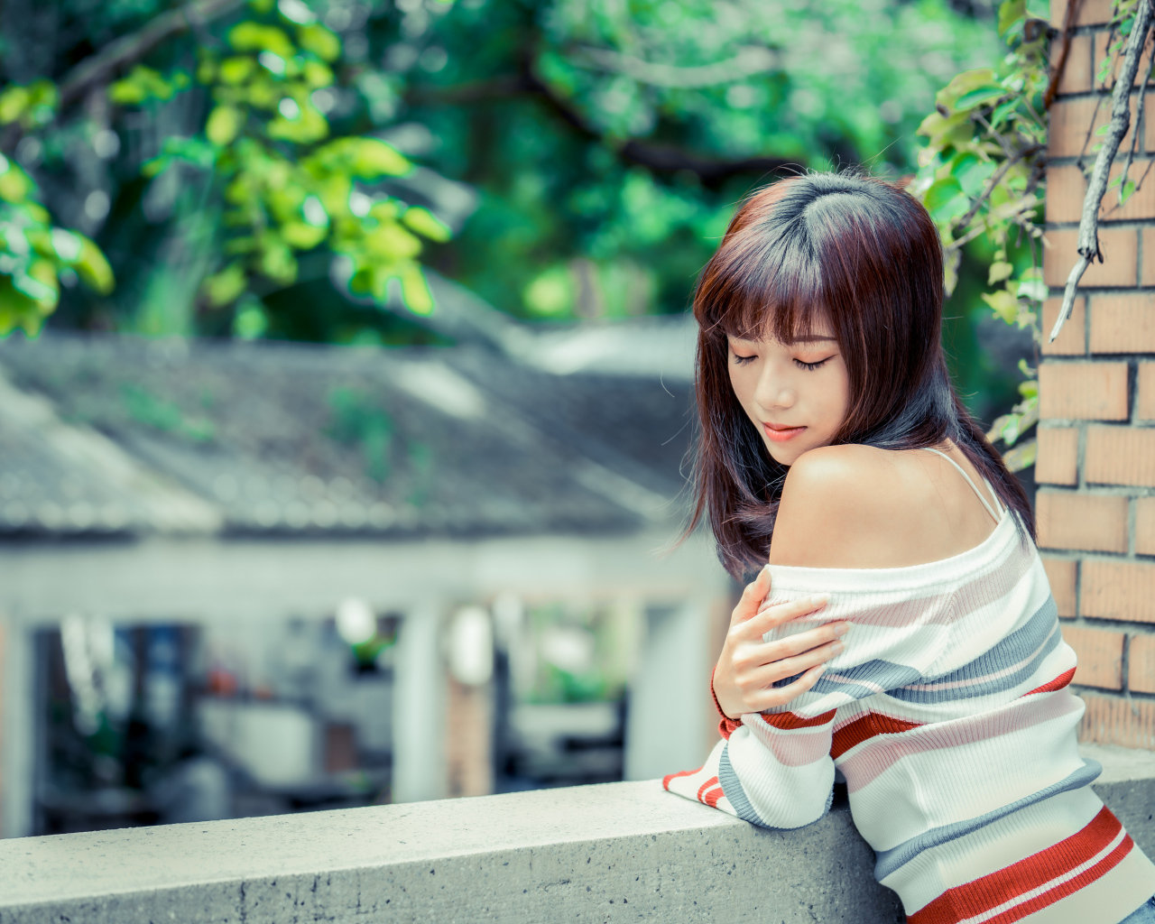 Нежная азиатка стоит на балконе