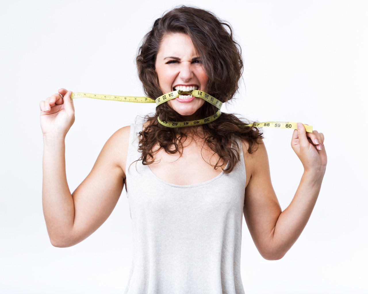 Блондинка в белой майке грызет сантиметр 