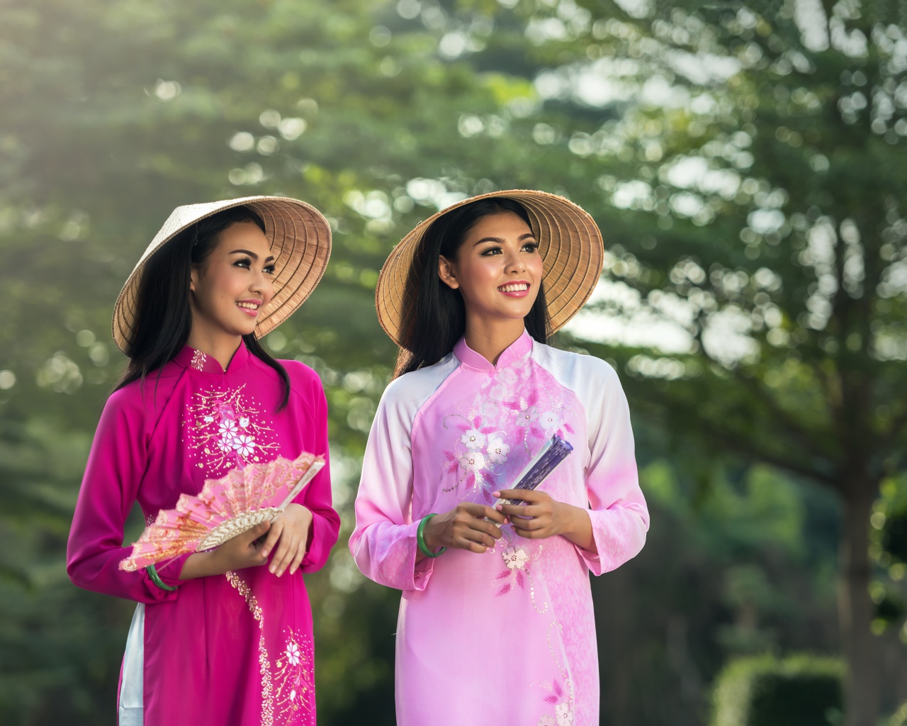 Две девушки азиатки в платьях с веером в руках