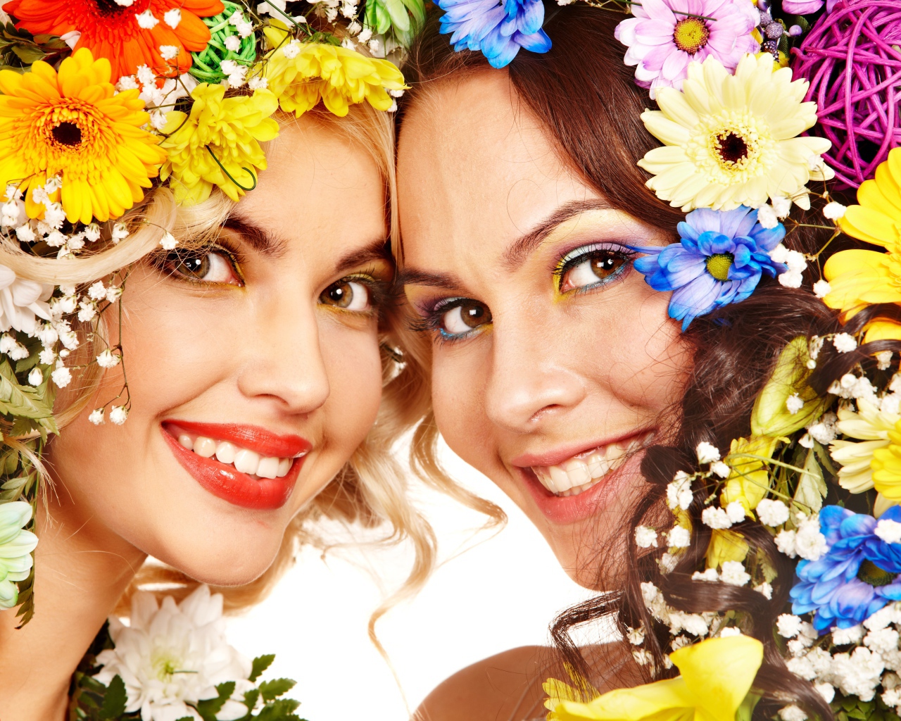 Две яркие улыбающиеся девушки с цветами в волосах 