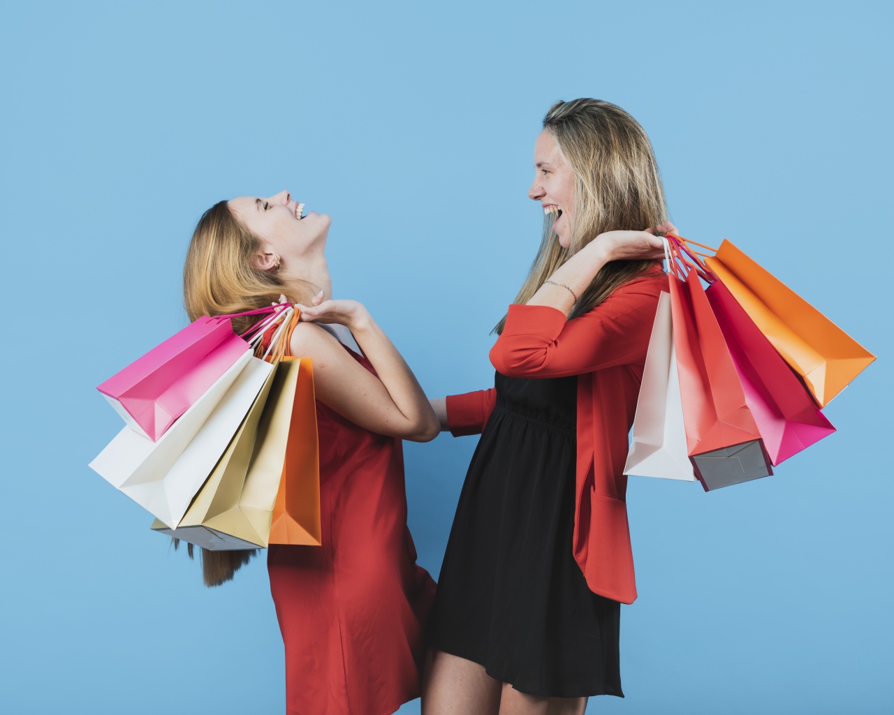 Две девушки с покупками на голубом фоне