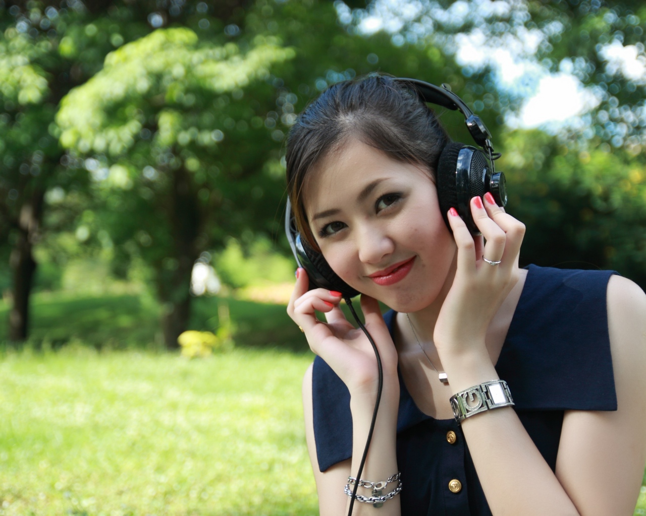 Молодая девушка азиатка в больших наушниках 