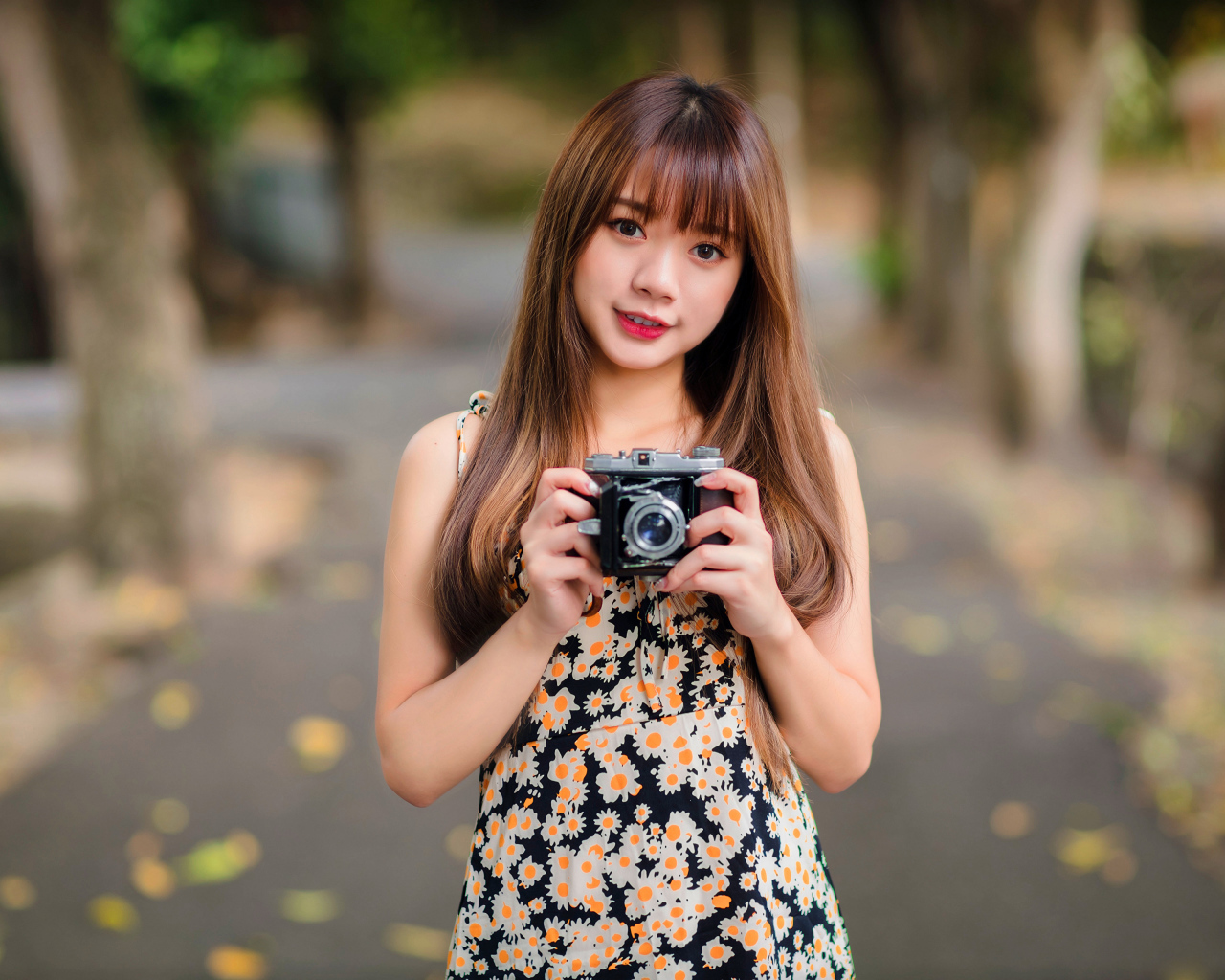 Молодая девушка азиатка с фотоаппаратом в руках 