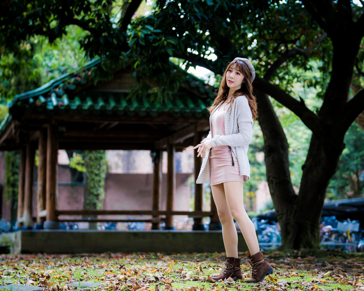 Молодая азиатка в теплой кофте в парке