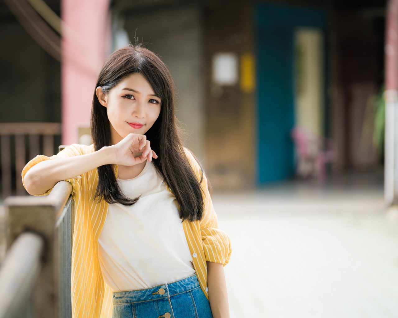 Молодая азиатка в белой майке и полосатой рубашке 