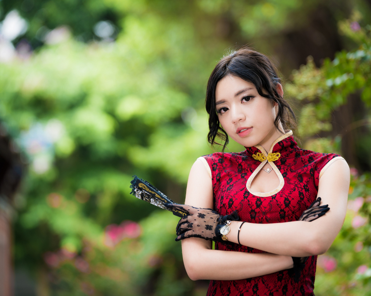 Молодая азиатка в красивом платье с веером в руке