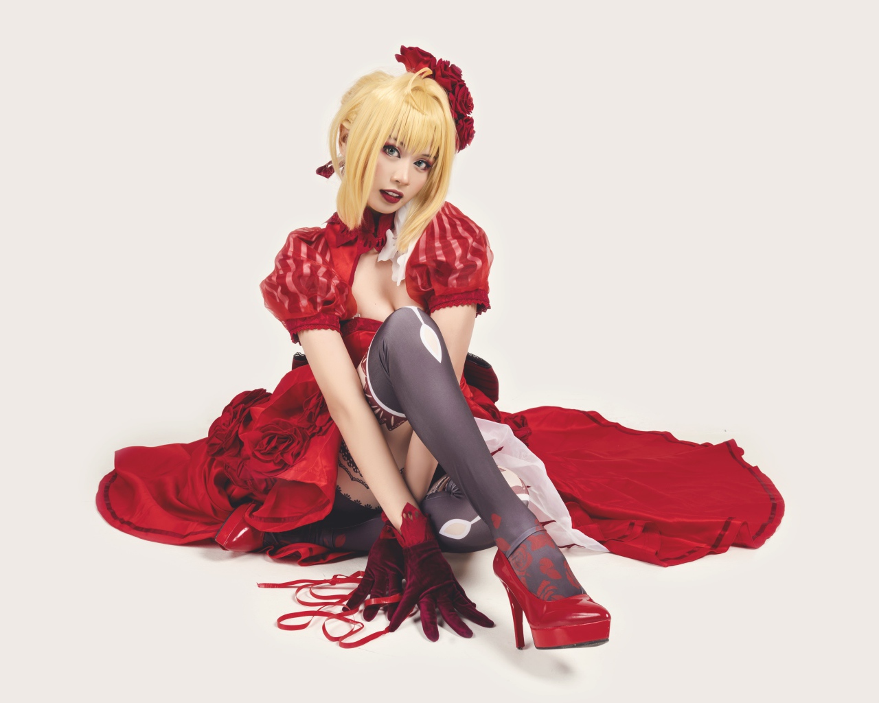 Молодая азиатка в ярком красном костюме на белом фоне