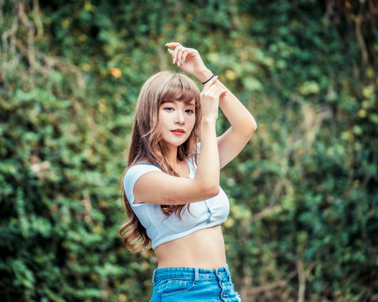 Молодая азиатка подняла руки вверх 