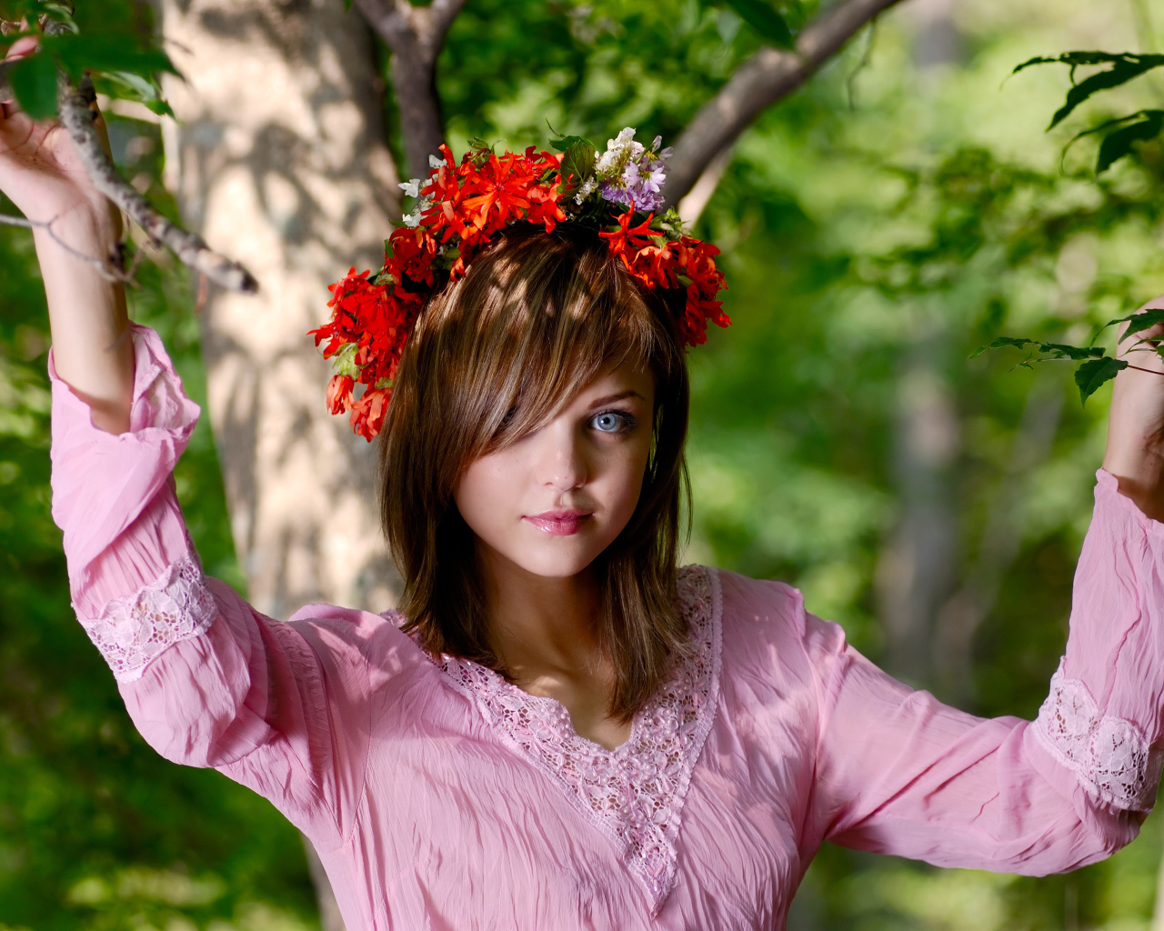 Молодая милая голубоглазая девушка с венком на голове у дерева