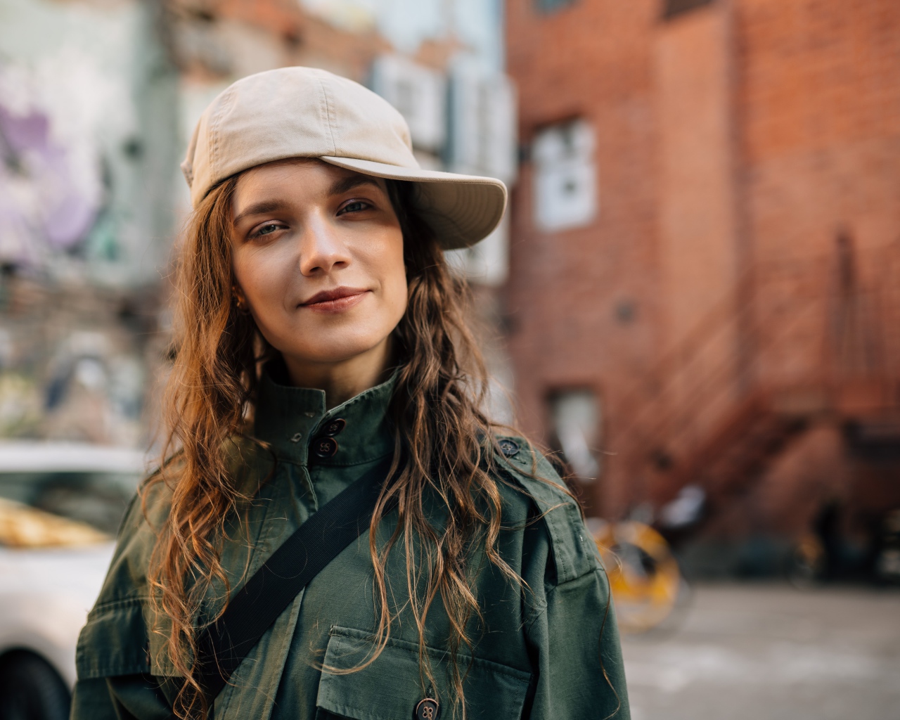 Young fashionable girl in a cap in the city