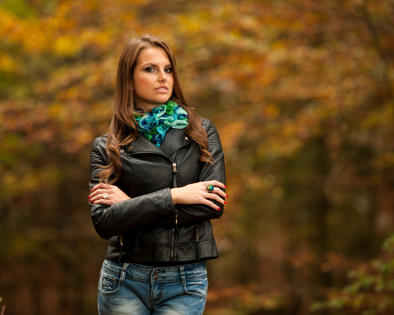 Молодая девушка в черной кожаной куртке  в парке