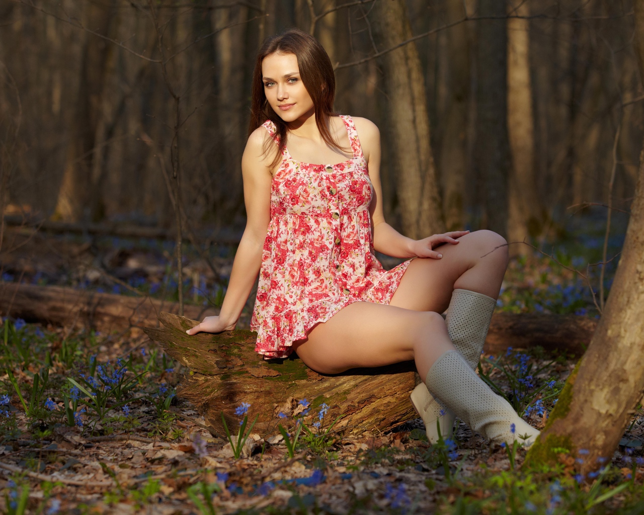 Молодая девушка в коротком платье в лесу весной