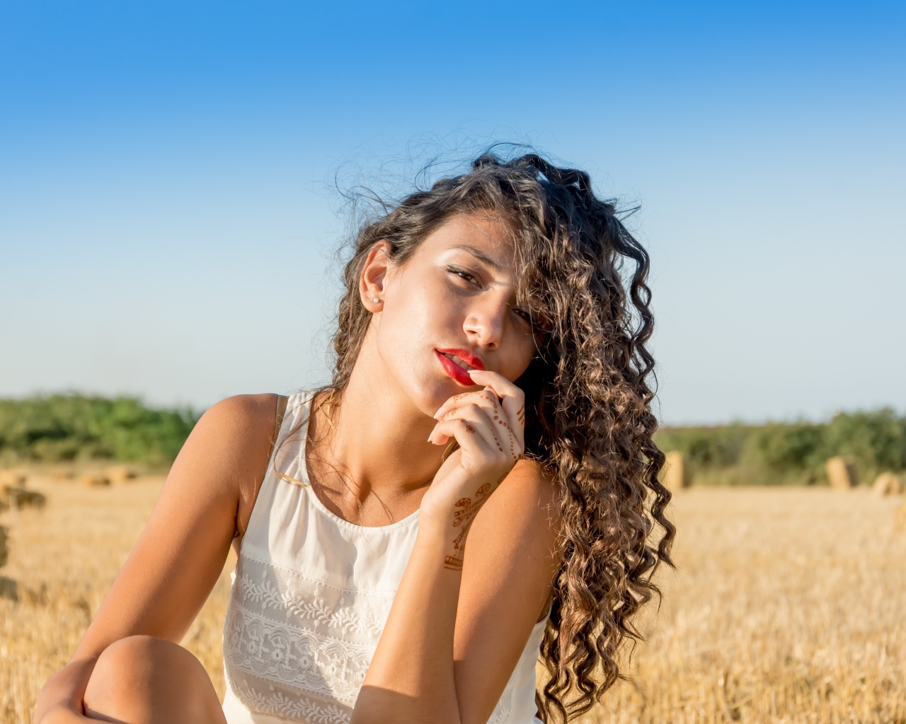 Молодая девушка в белом платье на пшеничном поле