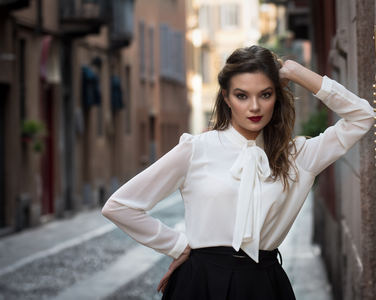 Молодая девушка в белой рубашке у стены