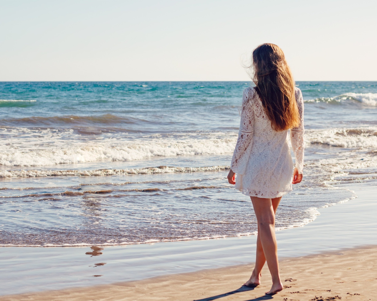 Молодая девушка в белом кружевном платье у моря