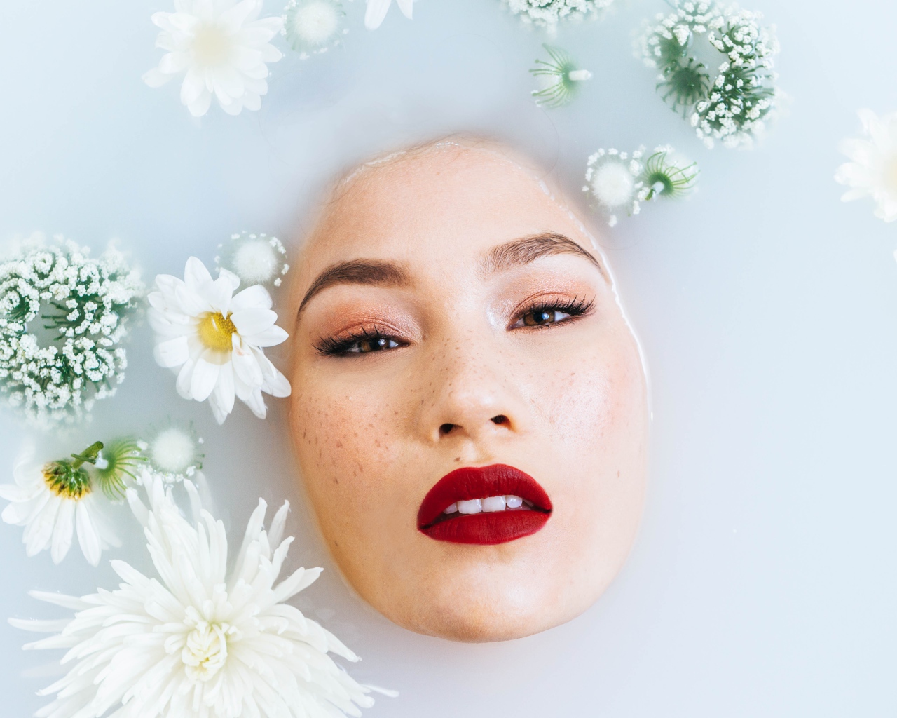 Молодая девушка лежит в ванной с цветами