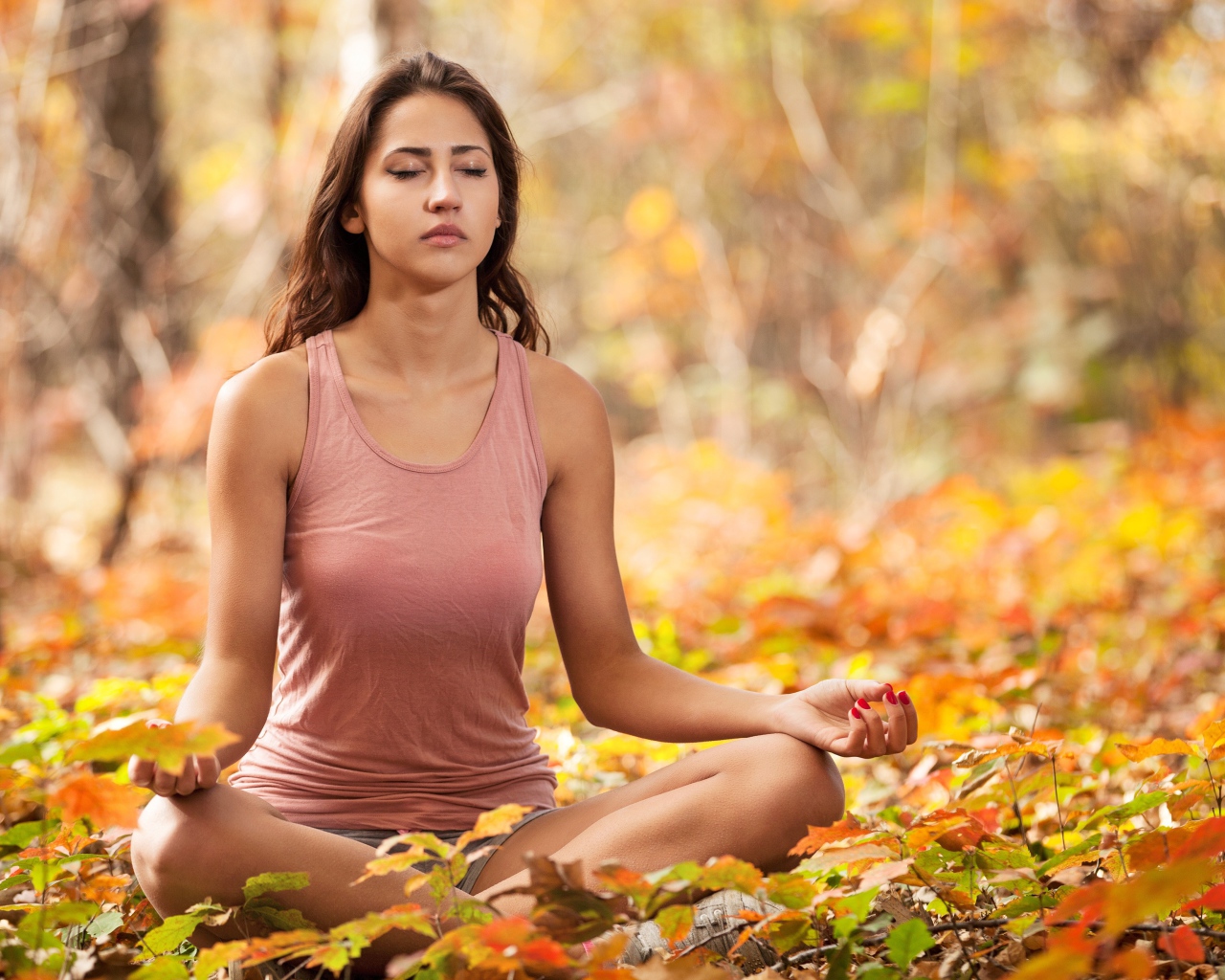 Молодая девушка медитирует в лесу 